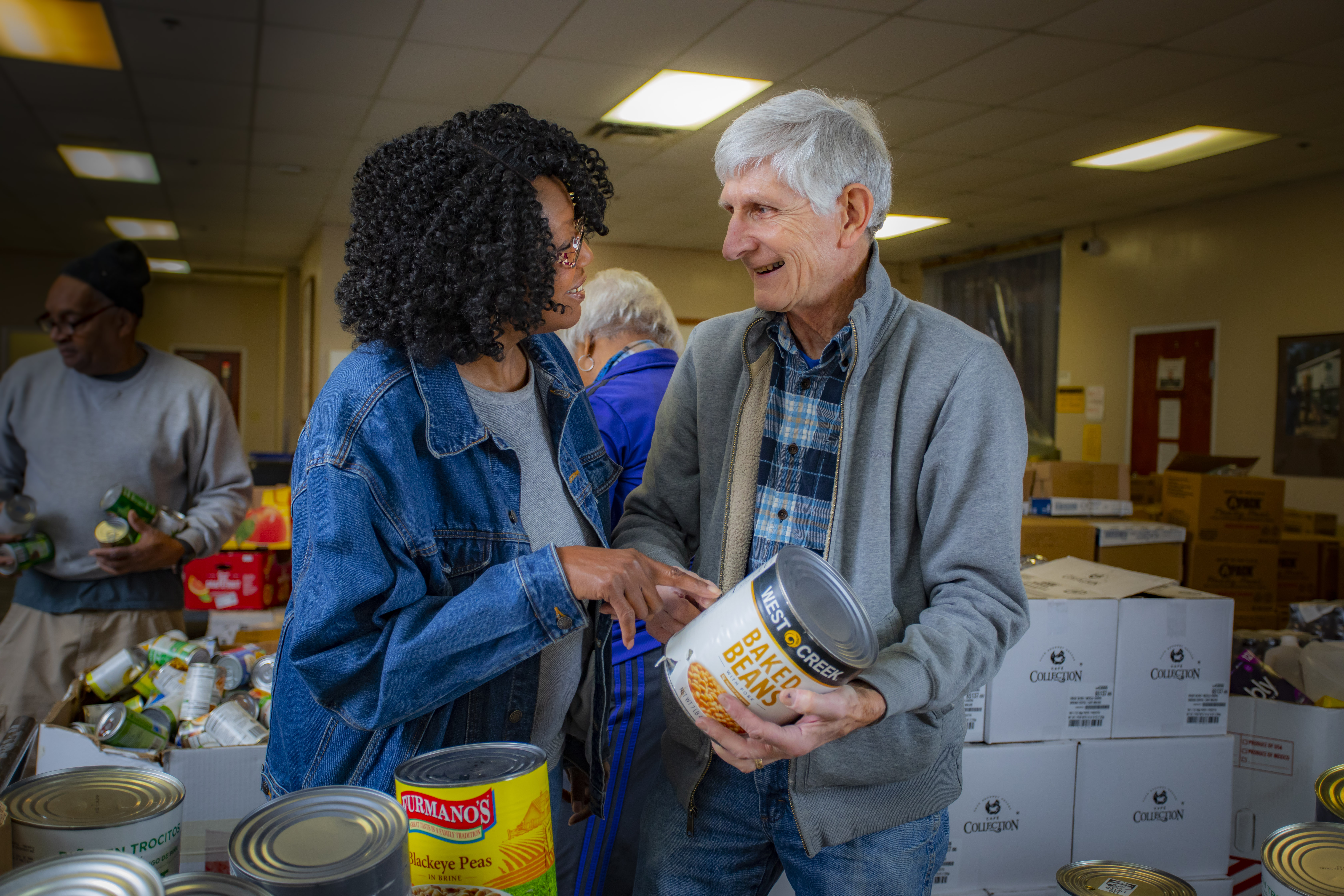 Volunteer helps client pick out food