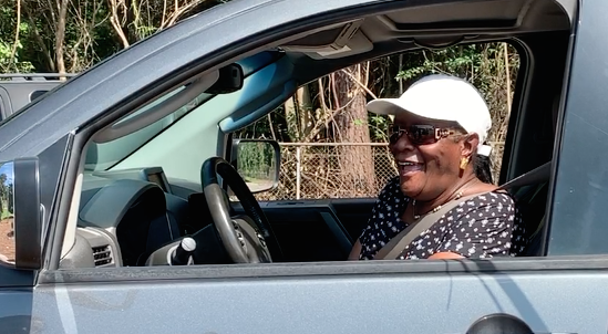 Delores smiling in her car